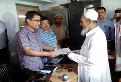 First Applicant of NRC Updation in Hailakandi Mr Abdul Jalil Mazumder receives his acknowledgement receipt from DC Shri Barun Bhuyan on 16th June, 2015.