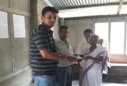 First Applicant of Jalukbari NSK, a senior citizen receives her acknowledgement slip from the NSK staff on 16th June, 2015.